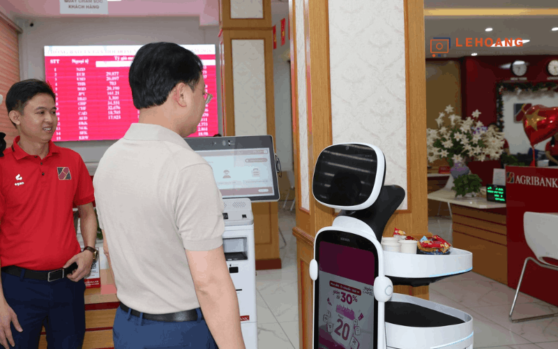 Robot KEENON T10 hoạt động bên cạnh máy giao dịch tự động tại Agribank Đông Hải Phòng hiển thị chương trình khuyến mãi
