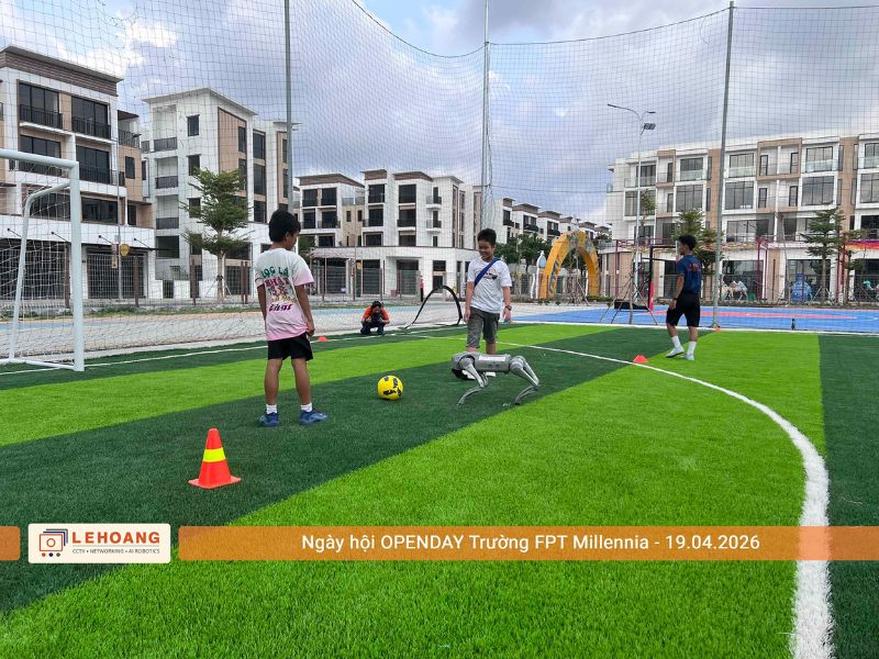 Robot chó Unitree đá bóng cùng học sinh trên sân cỏ nhân tạo tại Open Day Trường FPT Millennia 2026