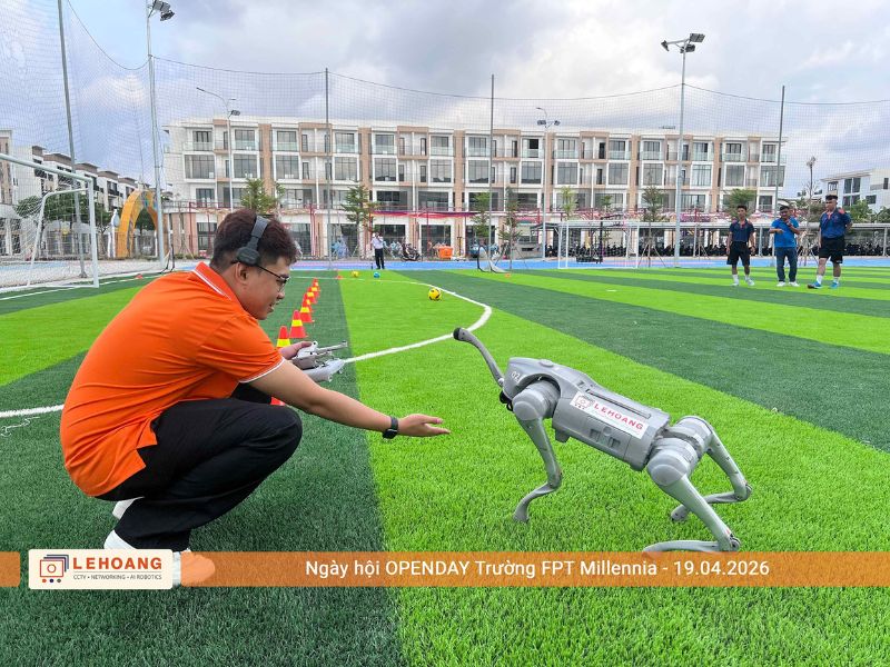 Nhân viên Lê Hoàng Robotics điều khiển robot chó Unitree trên sân cỏ tại Open Day Trường FPT Millennia 2026